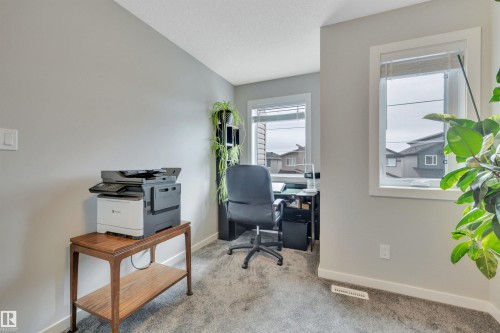 Room featuring light gray wall paint, gray carpeting, and white baseboards - 157 Larch Crescent, Leduc, AB 