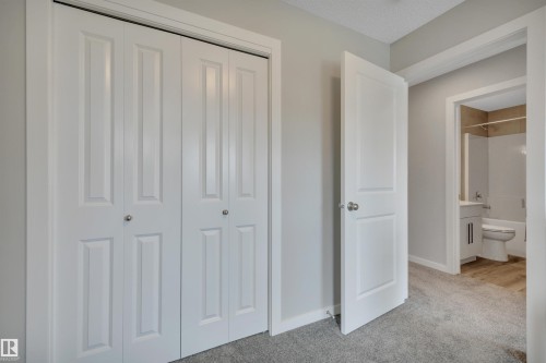 White bi-fold closet doors with polished nickel hardware - 157 Larch Crescent, Leduc, AB 