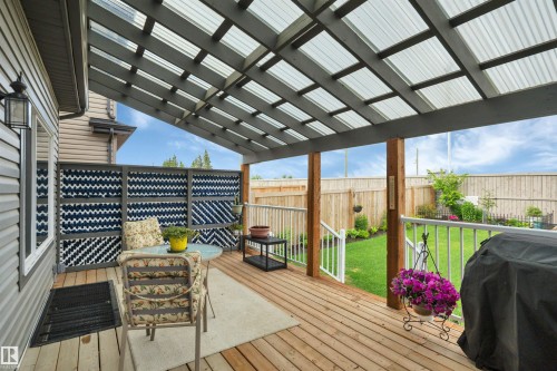 Covered outdoor deck featuring wood-finish flooring - 157 Larch Crescent, Leduc, AB 