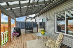Covered outdoor patio area featuring a wooden deck - 