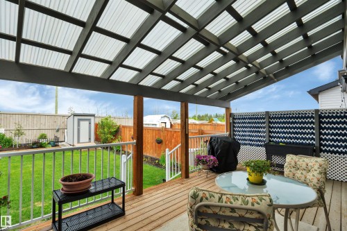 Expansive wood deck with a translucent corrugated roof covering - 157 Larch Crescent, Leduc, AB 
