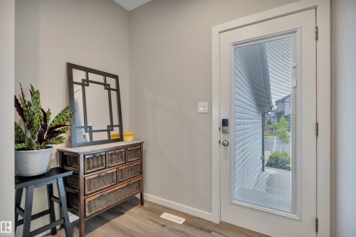 Entryway featuring light neutral wall paint and wood-finish flooring - 157 Larch Crescent, Leduc, AB 