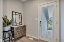 Entryway featuring light neutral wall paint and wood-finish flooring - 157 Larch Crescent, Leduc, AB 