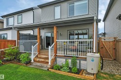 Covered deck featuring wood-finish support posts, white railings, and a privacy screen - 