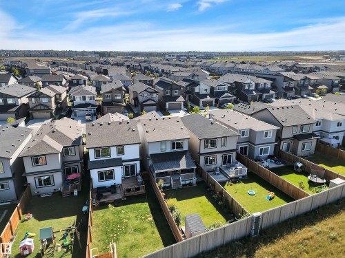 Contemporary residential development featuring a collection of two-story homes with dark shingle roofs, private fenced backyards, and rear decks - 157 Larch Crescent, Leduc, AB 