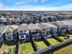 Contemporary residential development featuring a collection of two-story homes with dark shingle roofs, private fenced backyards, and rear decks - 