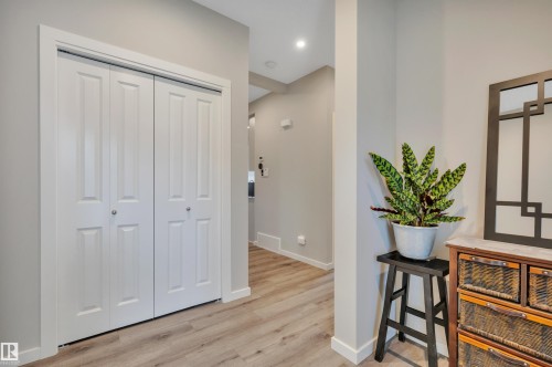 Hallway featuring light wood-finish flooring and a white bi-fold closet - 157 Larch Crescent, Leduc, AB 
