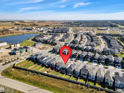 Aerial perspective showcasing a residential development with a prominent water feature - 157 Larch Crescent, Leduc, AB 