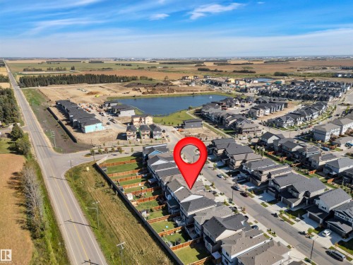 Aerial view showcasing a residential development with structured street layouts and individual properties - 157 Larch Crescent, Leduc, AB 