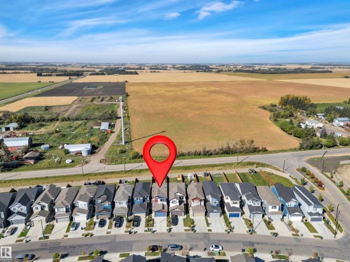 Residential streetscape featuring a collection of modern homes, each with a dedicated driveway and attached garage - 157 Larch Crescent, Leduc, AB 