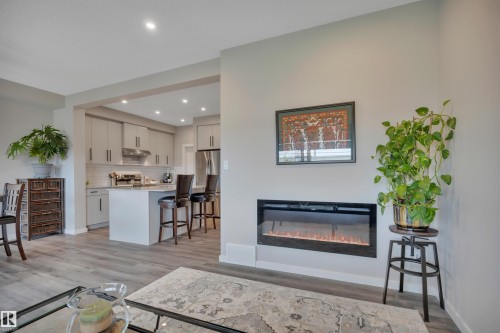 Electric fireplace integrated into a light gray wall - 157 Larch Crescent, Leduc, AB 