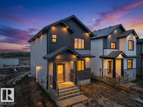 Modern two-story home featuring a combination of horizontal siding, vertical board and batten, and stone veneer accents - 18723 130 Street, Edmonton, AB 
