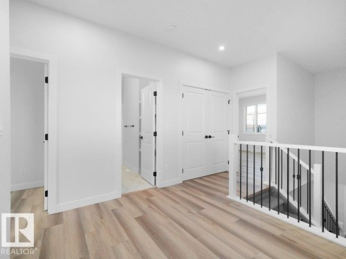 Bright hallway with light wood-finish flooring, white walls, and recessed lighting - 18723 130 Street, Edmonton, AB 