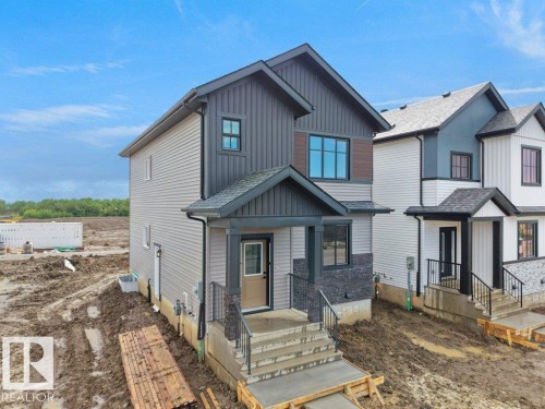 Contemporary residential exterior featuring a grey and dark grey siding facade with contrasting brown accents - 18723 130 Street, Edmonton, AB 