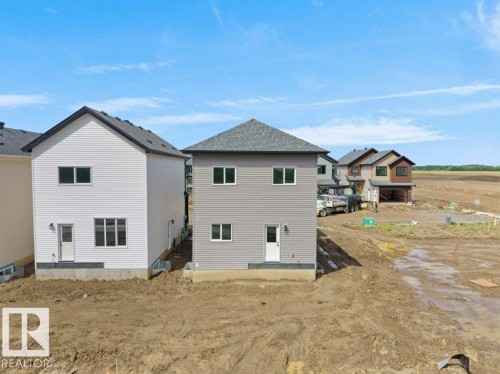 Two-story residential structure featuring gray horizontal siding and a dark shingle roof - 18723 130 Street, Edmonton, AB 