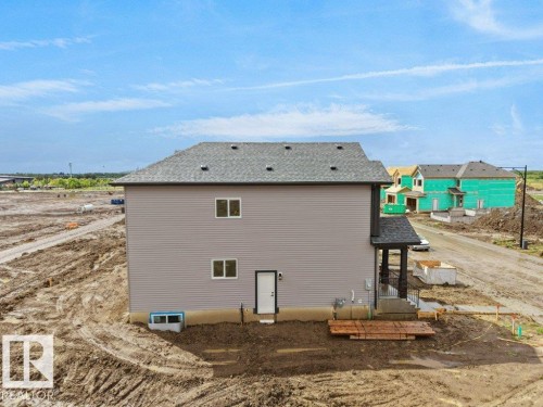 New construction residence featuring grey horizontal siding and a dark shingle roof - 18723 130 Street, Edmonton, AB 