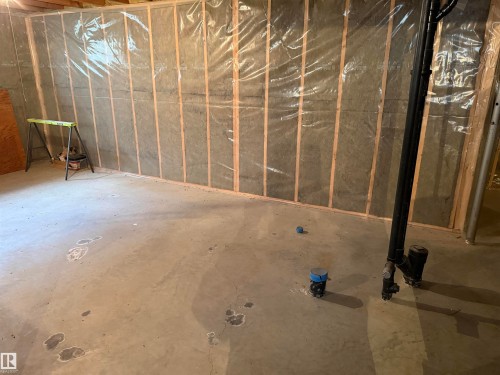 Unfinished basement space featuring exposed wood framing, insulation, and a concrete floor - 5319 63 Street, Redwater, AB 
