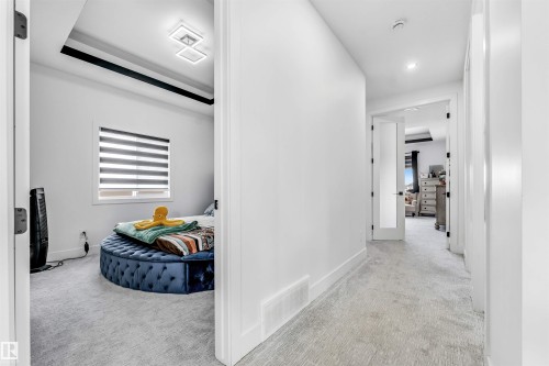 Hallway featuring light-toned carpeting and white baseboards - 208 33 Street, Edmonton, AB 