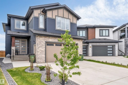 Contemporary exterior featuring dark blue siding and light-toned stone veneer - 208 33 Street, Edmonton, AB 