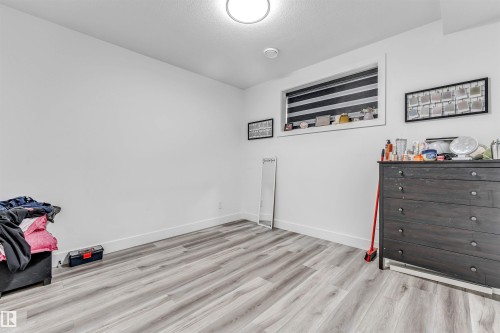 Room featuring light wood-finish flooring and white walls - 208 33 Street, Edmonton, AB 