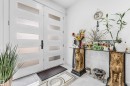 Double entry doors with frosted glass panels, black hardware, and polished tile flooring - 208 33 Street, Edmonton, AB 