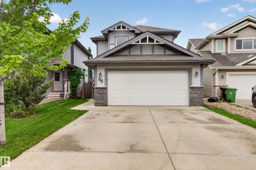 Contemporary two-story residence featuring a prominent front-facing double garage, stone column accents, and gabled rooflines - 74 Santana Crescent, Fort Saskatchewan, AB 