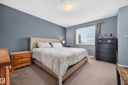 Bedroom featuring soft gray-blue walls and plush carpet flooring - 74 Santana Crescent, Fort Saskatchewan, AB 