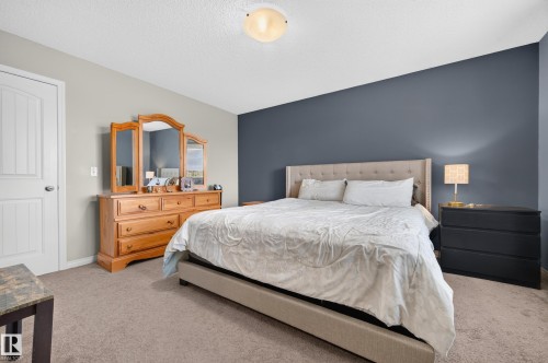 Carpeted room with a feature wall in a deep blue tone - 74 Santana Crescent, Fort Saskatchewan, AB 