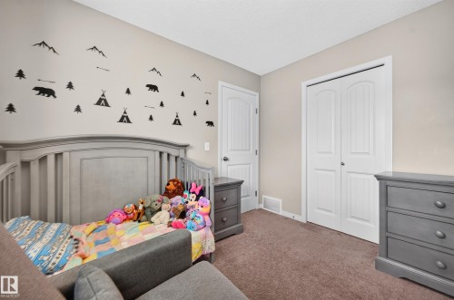 Bedroom featuring neutral wall paint, white trim, and a textured carpet - 74 Santana Crescent, Fort Saskatchewan, AB 