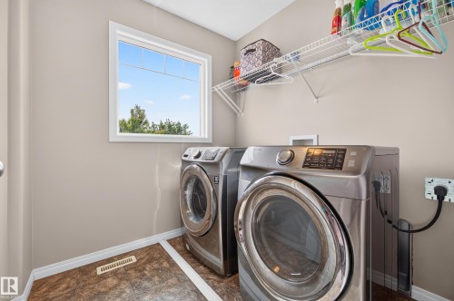 Dedicated laundry space featuring a window, built-in wire shelving, durable flooring, and light-toned wall paint - 74 Santana Crescent, Fort Saskatchewan, AB 