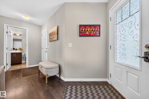 Entryway featuring wood-finish flooring and a decorative glass-paneled entry door - 74 Santana Crescent, Fort Saskatchewan, AB 