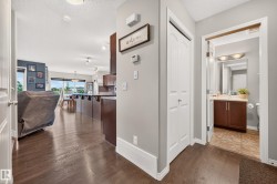 Hardwood-style flooring extends through the entryway, opening to a spacious living area with ample natural light - 