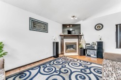 Living area featuring a fireplace with a wood mantle, tiled surround, and hearth - 