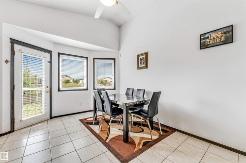 Dining area featuring tiled flooring, a vaulted ceiling, and a ceiling fan - 6719 164 Ave, Edmonton, AB 