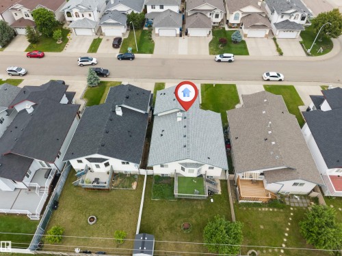 Property featuring a light gray shingle roof, rear deck with wood railing, and a grass lawn - 6719 164 Ave, Edmonton, AB 