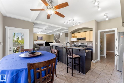 Open-concept kitchen featuring tile flooring, a breakfast bar, and track lighting - 488 Macewan Road, Edmonton, AB 