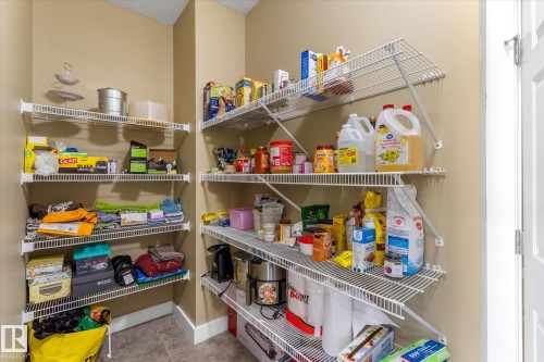 Built-in wire shelving system providing ample storage, neutral wall paint, and durable tile flooring - 488 Macewan Road, Edmonton, AB 