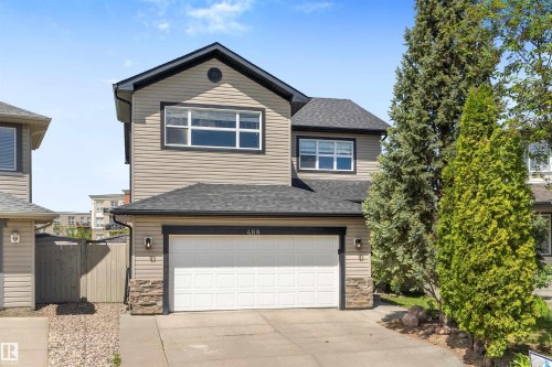 Two-story residence featuring light-toned siding, a dark shingled roof, and dark trim - 488 Macewan Road, Edmonton, AB 