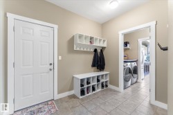 Mudroom featuring light neutral wall paint, white trim, and square tile flooring - 