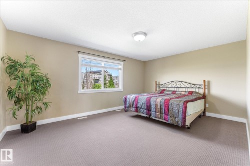 Spacious room featuring neutral paint, textured carpet flooring, and a large window with white blinds - 488 Macewan Road, Edmonton, AB 