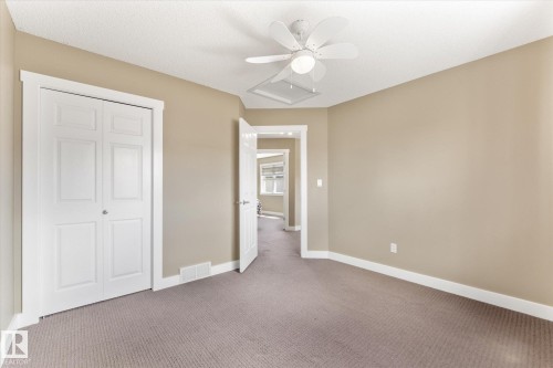 Room featuring neutral wall tones, textured carpeting, and white trim - 488 Macewan Road, Edmonton, AB 