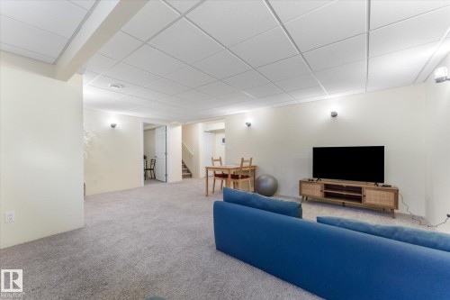 Spacious finished basement featuring light-colored walls, recessed ceiling panels, and light gray carpeting - 488 Macewan Road, Edmonton, AB 