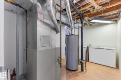 Utility room featuring mechanical systems, wood-finish flooring, and exposed ceiling joists - 