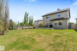 Spacious backyard featuring a large lawn, a multi-level deck, and a privacy fence - 