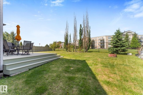 Expansive green lawn with a multi-level deck featuring composite decking - 488 Macewan Road, Edmonton, AB 