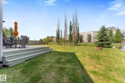 Expansive green lawn with a multi-level deck featuring composite decking - 