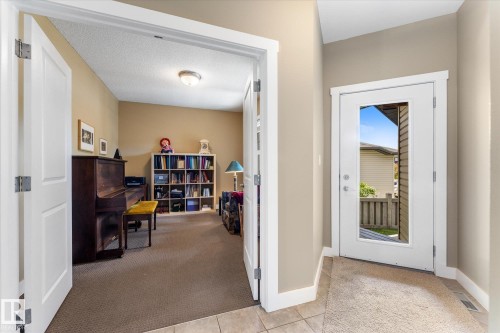 Interior entryway featuring a white glass-paneled door, tile flooring, and neutral wall tones - 488 Macewan Road, Edmonton, AB 