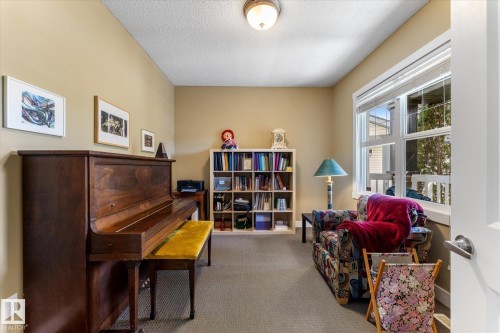 Carpeted room with a large window, neutral wall paint, and a built-in bookshelf - 488 Macewan Road, Edmonton, AB 