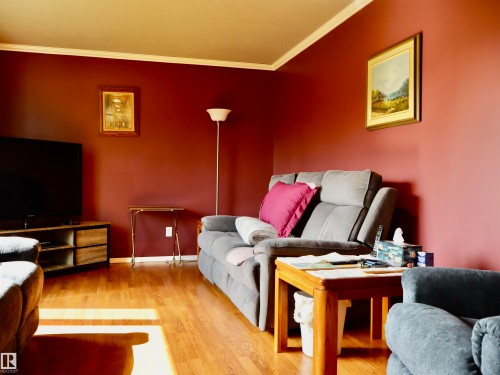 Interior room featuring red-toned walls and wood-finish flooring - 5530 46 Street, Barrhead, AB 