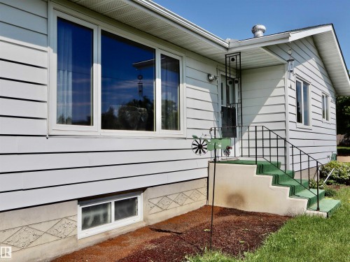 White horizontal siding exterior with multiple windows - 5530 46 Street, Barrhead, AB 